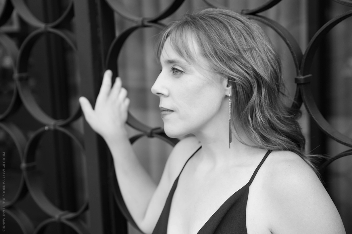 Color headshot of LV Wood semi-casual leaning against a rock wall