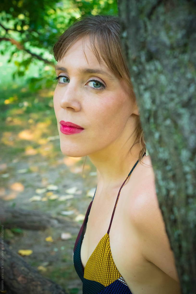 Color headshot of LV Wood standing in front of graffiti art